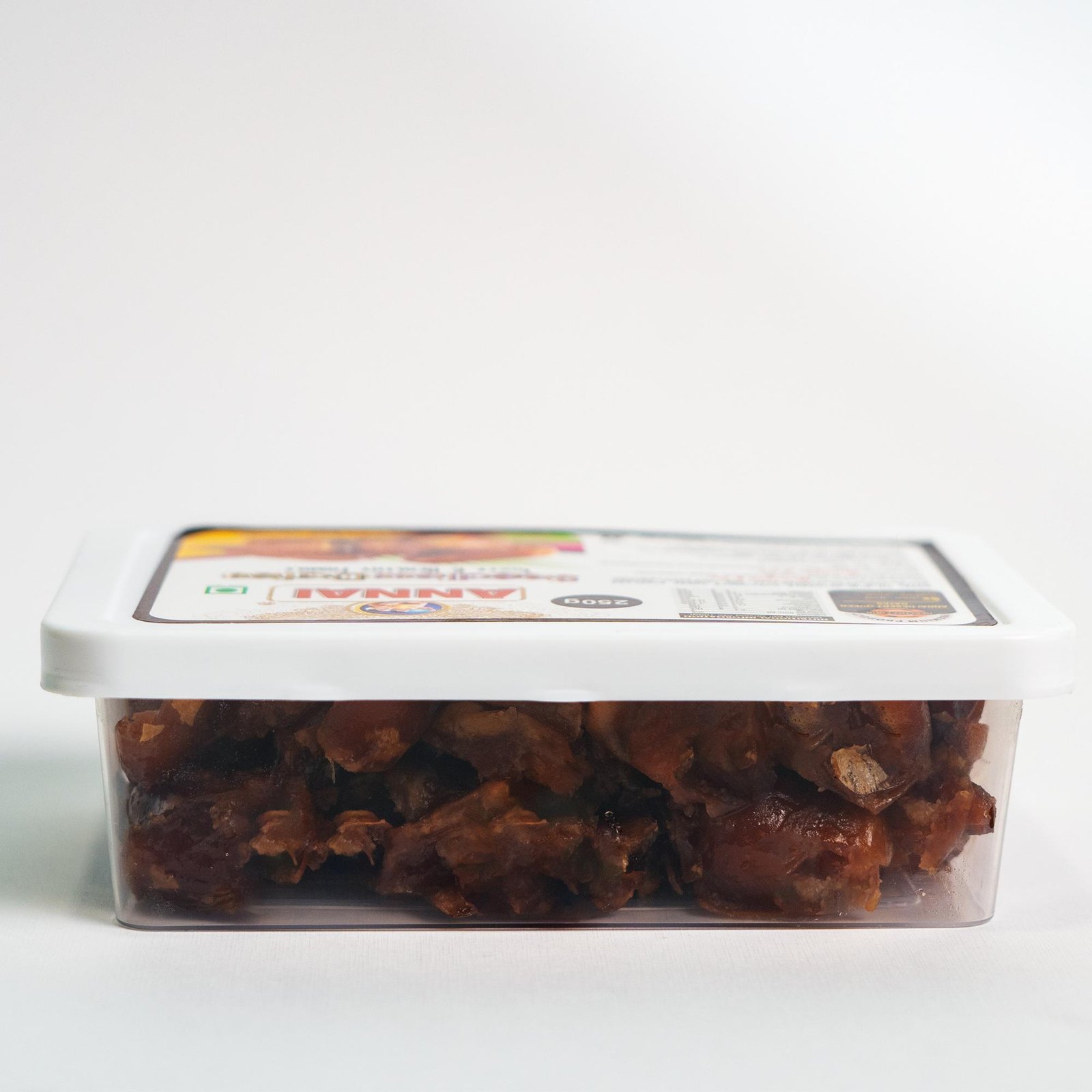 Side view of Annai Premium Seedless Wet Dates packed in a transparent square container